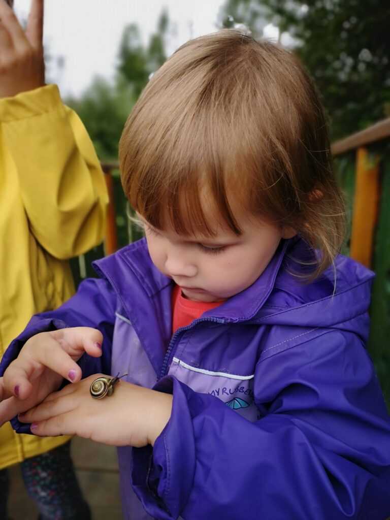 Uśmiechnięta dziewczyna na placu zabaw w samochodziku